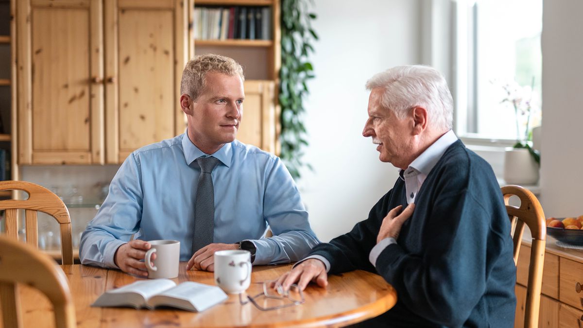 Ein junger Ältester besucht einen älteren Bruder und hört ihm aufmerksam zu.