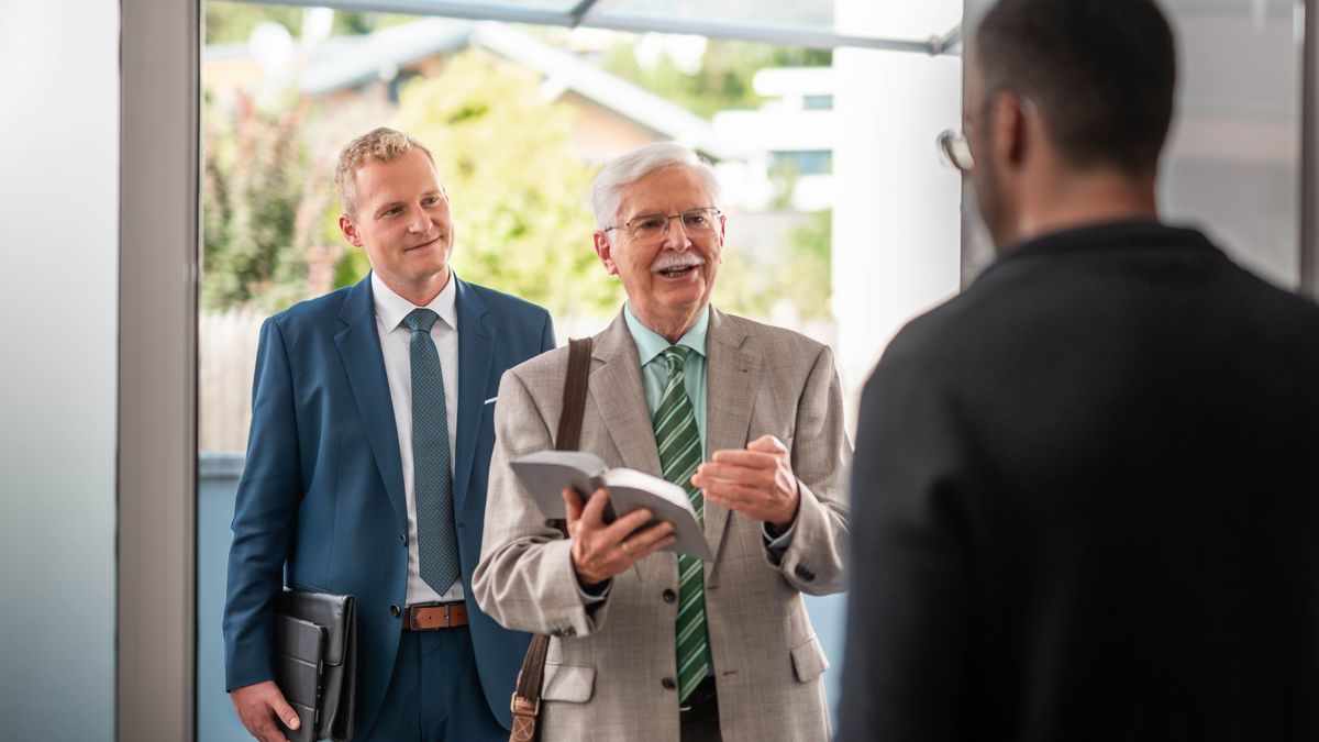 Der Älteste und der ältere Bruder im Haus-zu-Haus-Dienst. Der ältere Bruder spricht mit einem Mann voller Überzeugung über einen Bibeltext.