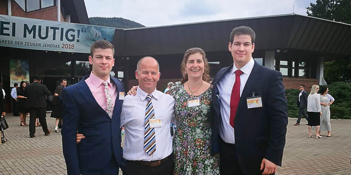 Artan, Julinda y sus dos hijos en una asamblea de los testigos de Jehová.