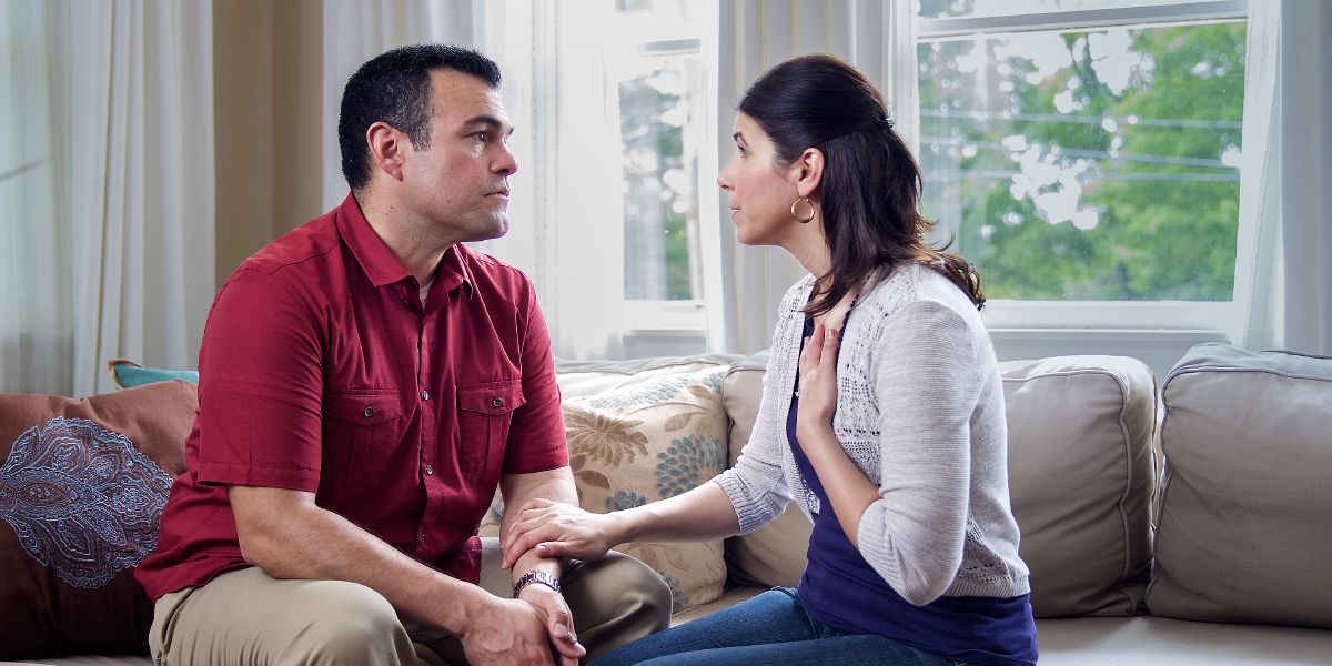 A couple sit together and the husband listens as his wife expresses herself