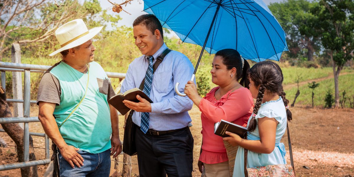 Óscar Serpas, accompanied by his wife and daughter, preaches to a man