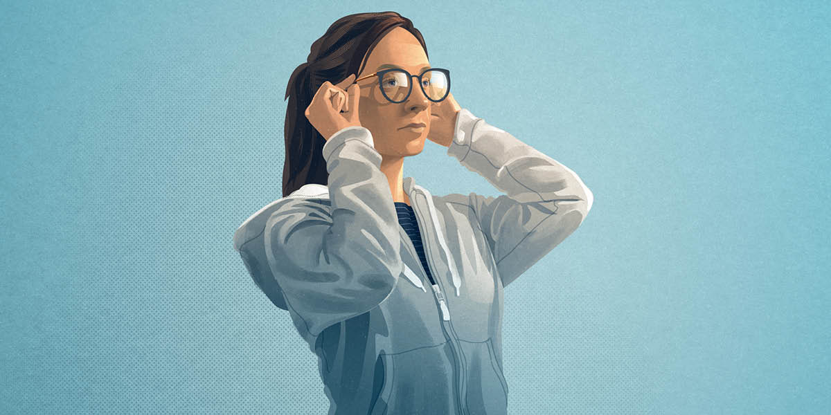 A teenage girl putting on eyeglasses.