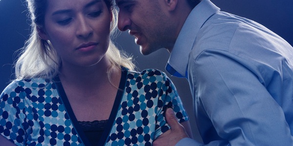 A man grabs hold of a teenage girl by the arm