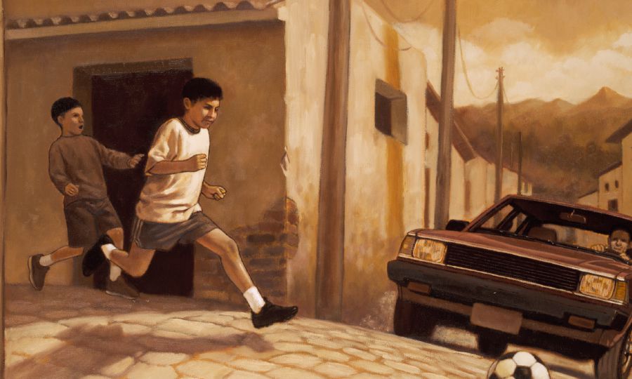 Two boys play in the street as a car approaches