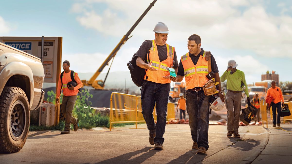 A brother offering a tract to a coworker as they leave the construction site where they were working.