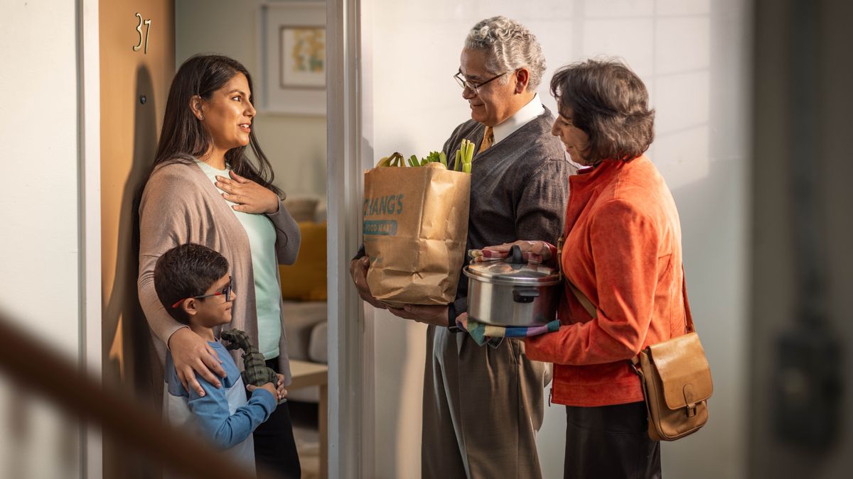 A brother and his wife bringing some groceries and a hot meal to the grateful mother and her son.