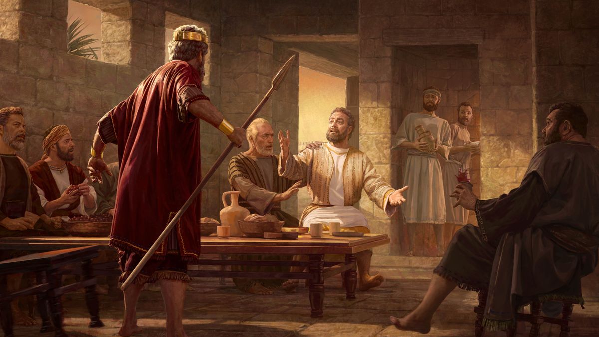 King Saul standing threateningly over Jonathan, who is sitting at the dining table and speaking up in David’s defense. Abner and the others in the room watch anxiously.