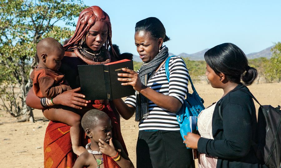 Two of Jehovah’s Witnesses preach to a Himba woman in Namibia