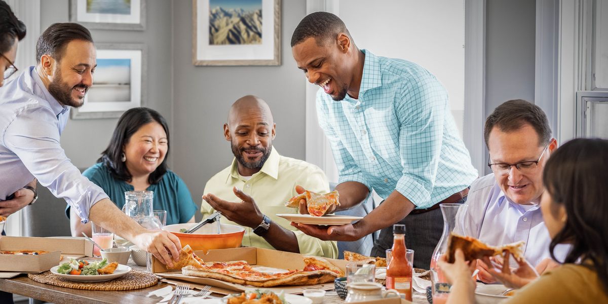 Un grupo de hermanos y hermanas disfrutan de una comida juntos en una casa.