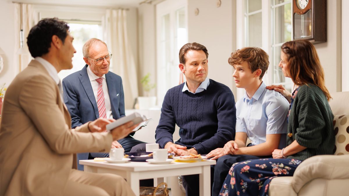 Kaks kogudusevanemat on ristitud alaealise ja tema vanematega nende kodus kokku saanud. Üks kogudusevanem loeb piibliteksti.