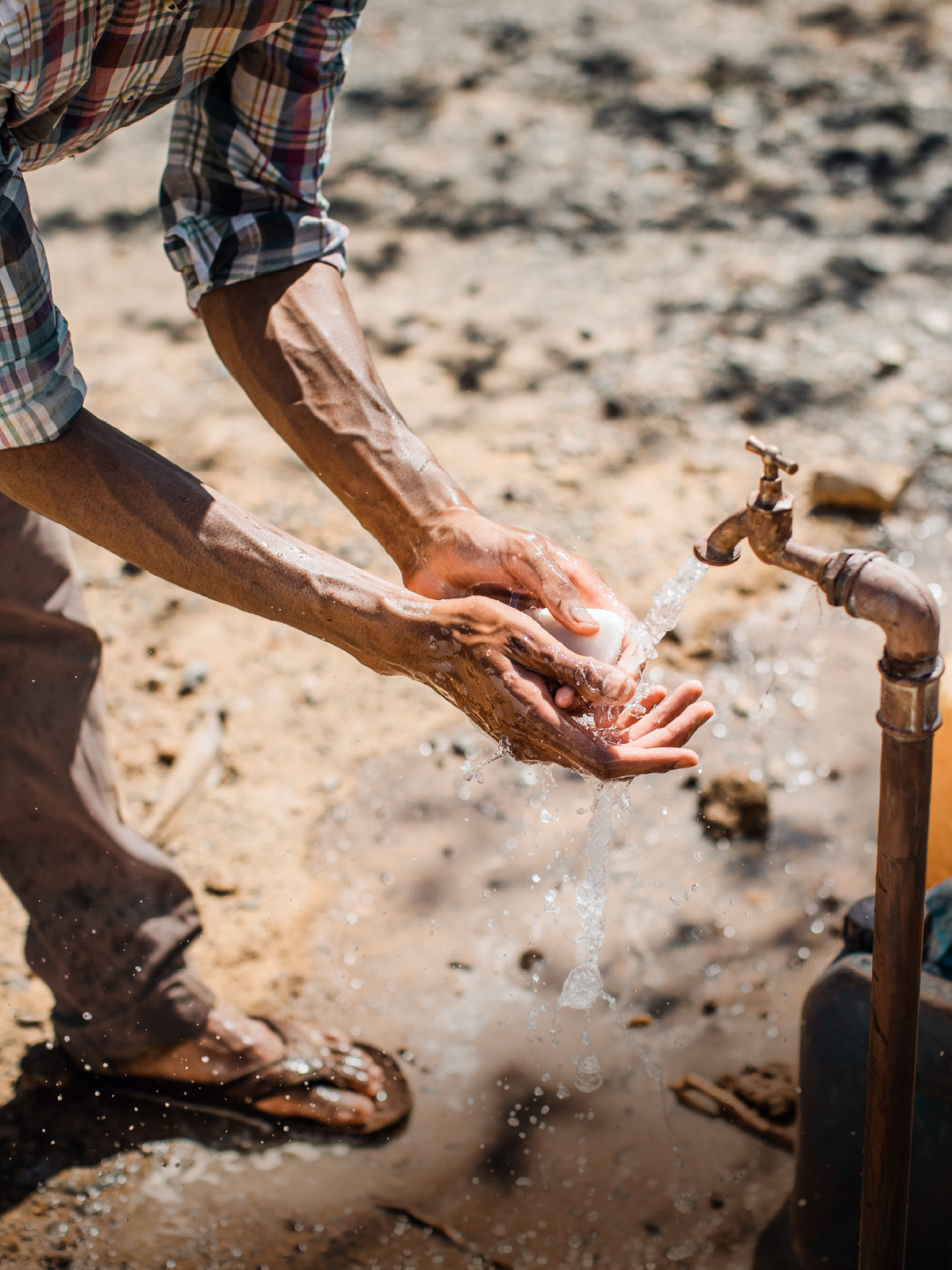 مردی دست‌هایش را با آب و صابون می‌شوید.‏