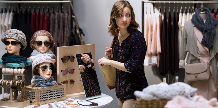 Une femme vole des lunettes de soleil dans un magasin