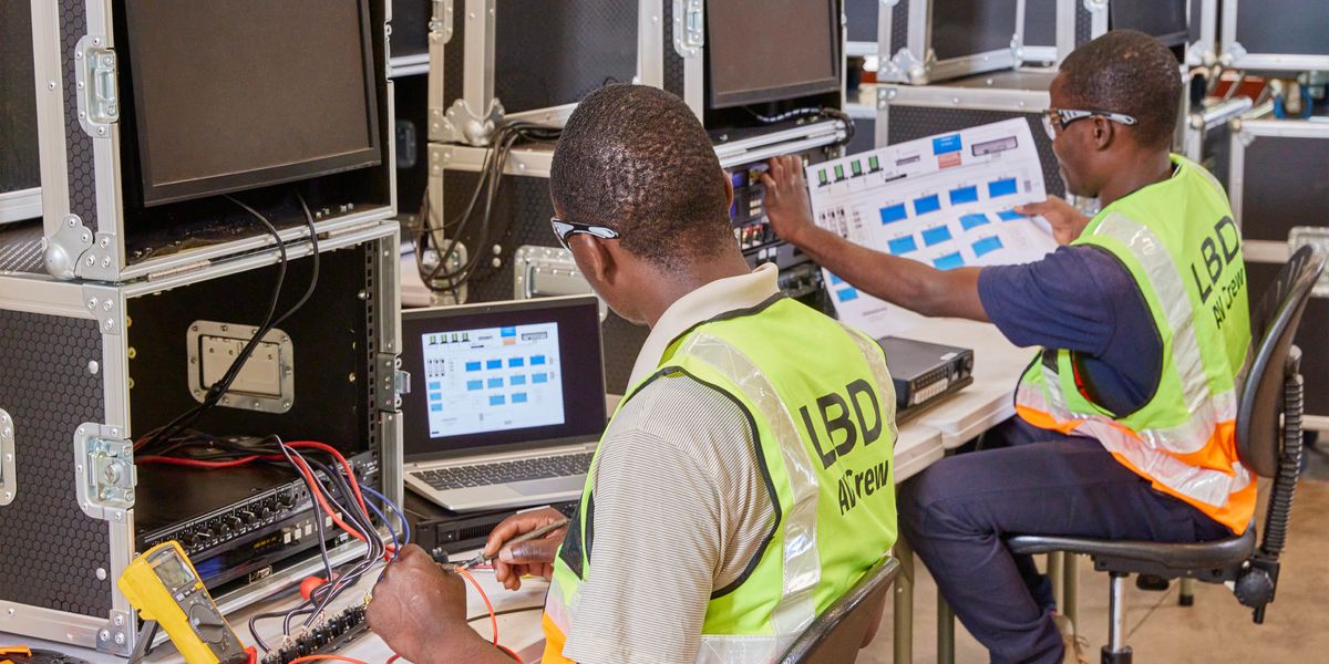 Deux frères du service local de la télédiffusion installent le matériel audio-vidéo pour une assemblée régionale.