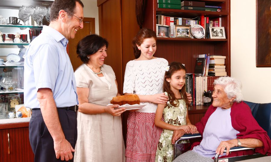 Une famille apporte à manger à une femme âgée
