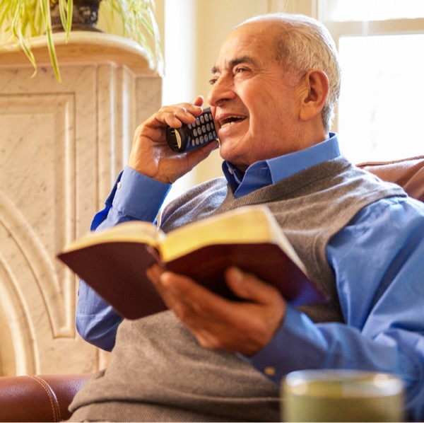 Un frère âgé au téléphone communiquant une pensée biblique à un compagnon chrétien