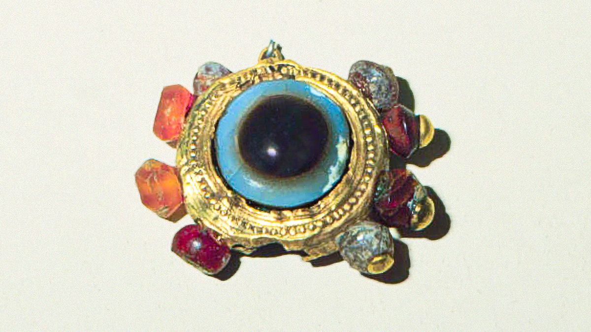 Un bijou en métal précieux serti de pierres colorées.