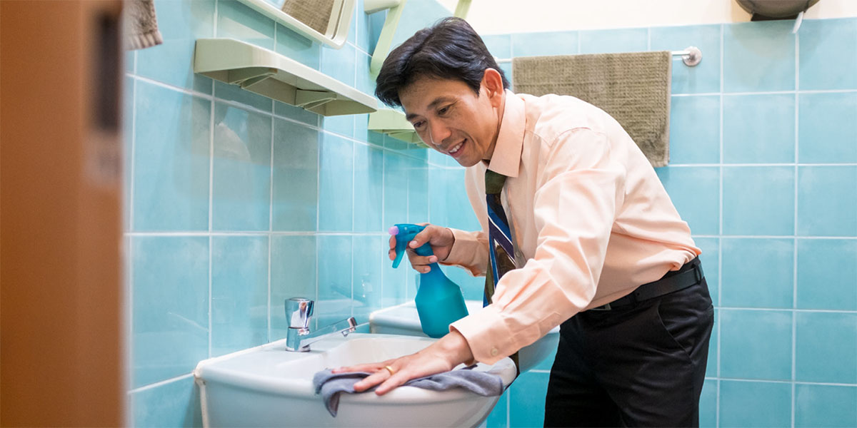 Un frère nettoie les toilettes de la Salle du Royaume