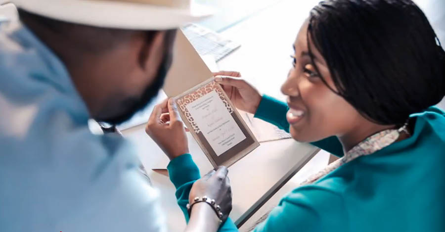 Image extraite de la vidéo « Gardez une bonne conscience ». Emma et son mari regardent une invitation à un mariage.