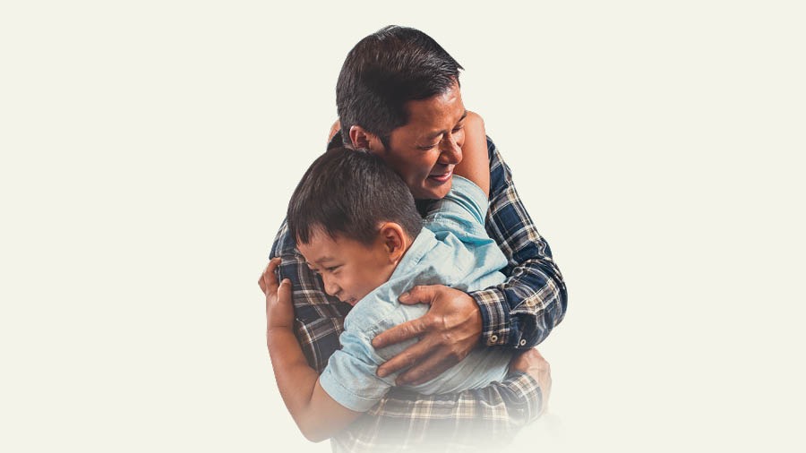 Un père prend son fils dans ses bras.
