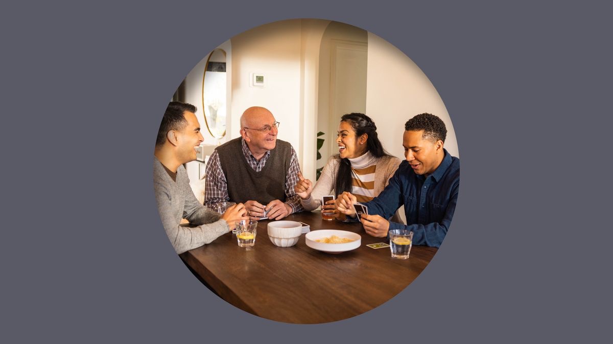 A couple and a younger brother happily associating with an older brother at his home.