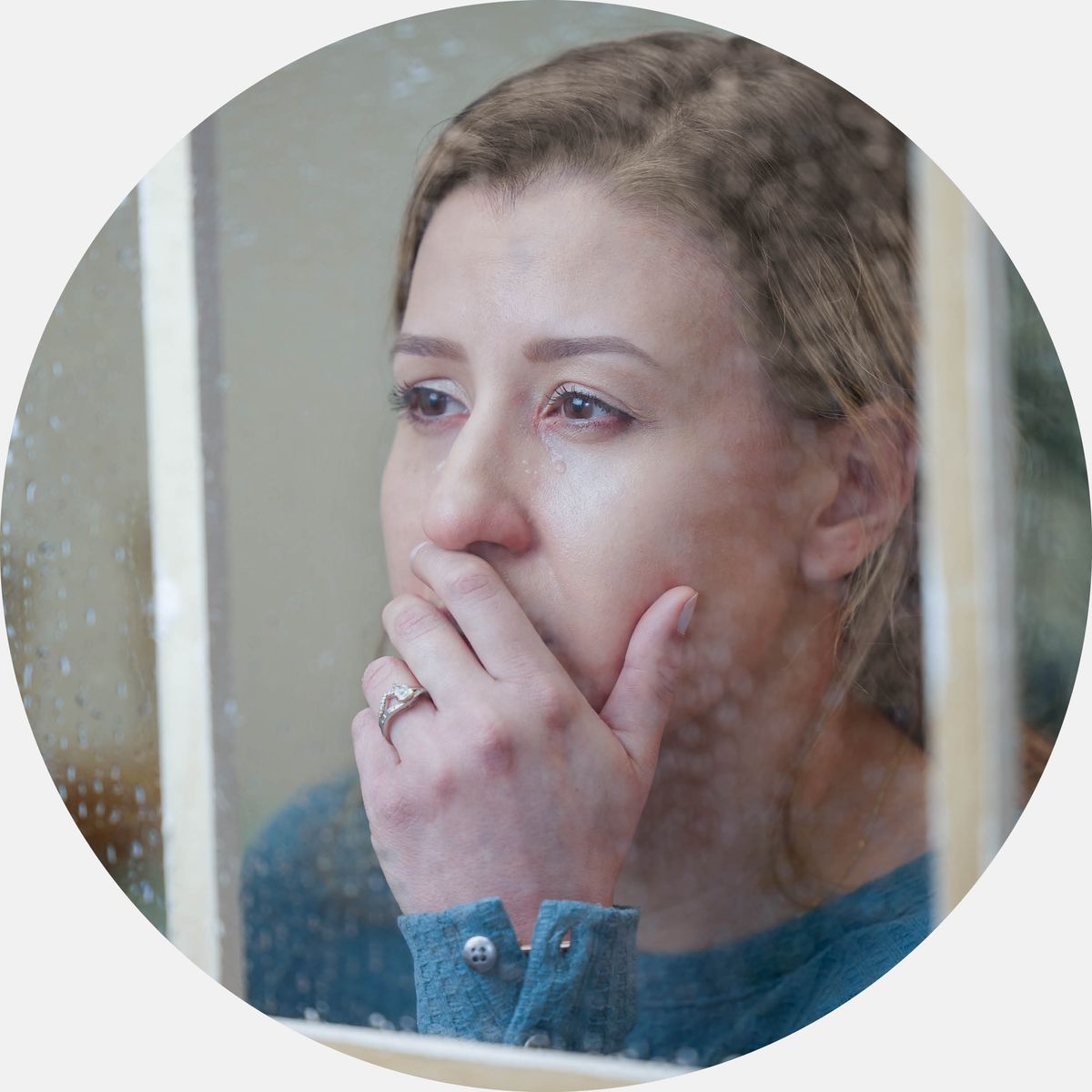 A distressed sister gazing out a window.