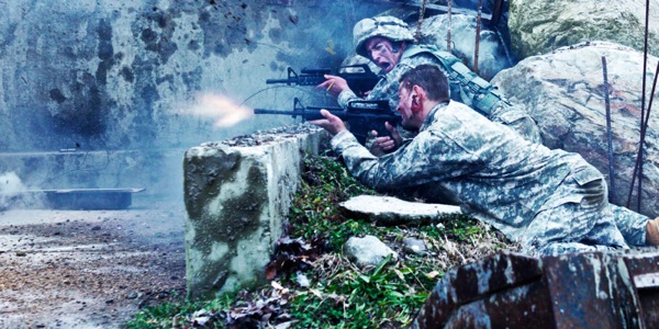 Uns soldados con uniformes de camuflaxe disparando nunha batalla