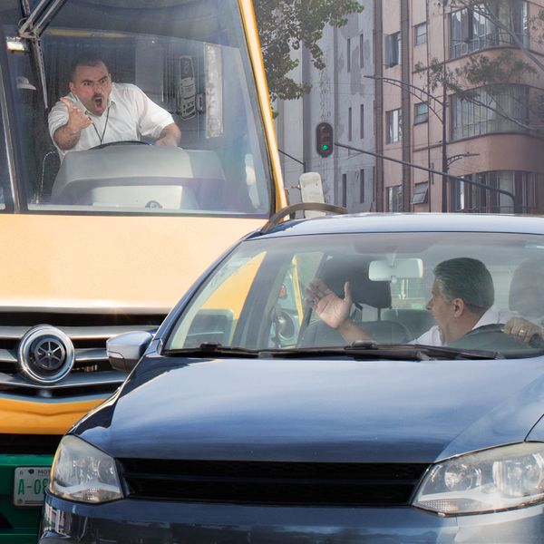 Ein verärgerter Busfahrer schreit einen Autofahrer an, der ihn im Verkehr geschnitten hat.