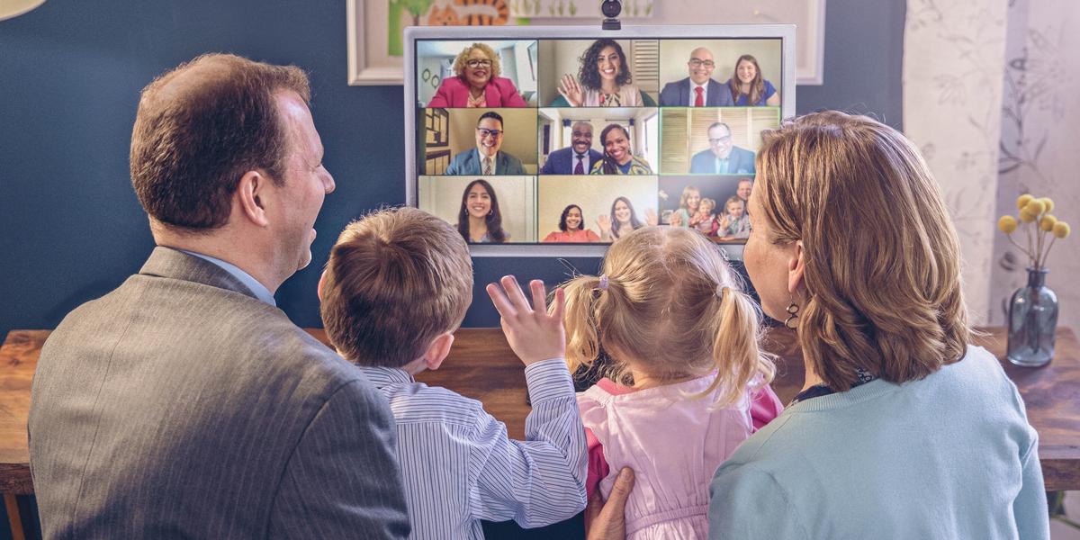 Eltern und ihre zwei kleinen Kinder sind mit ihrer Versammlung per Videokonferenz verbunden.