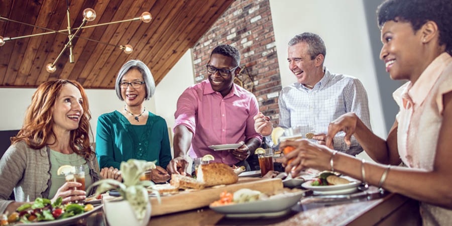 Freunde unterschiedlicher Herkunft und Hautfarbe bei einem Essen