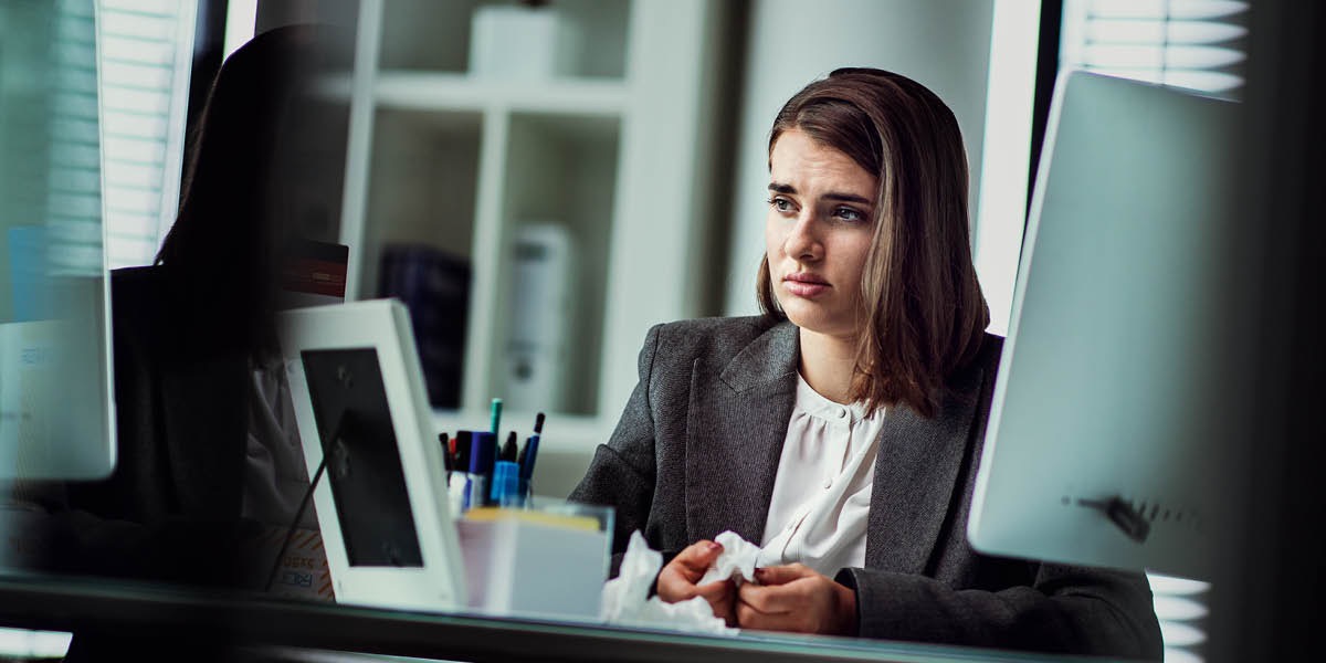 Eine junge Frau weint am Arbeitsplatz