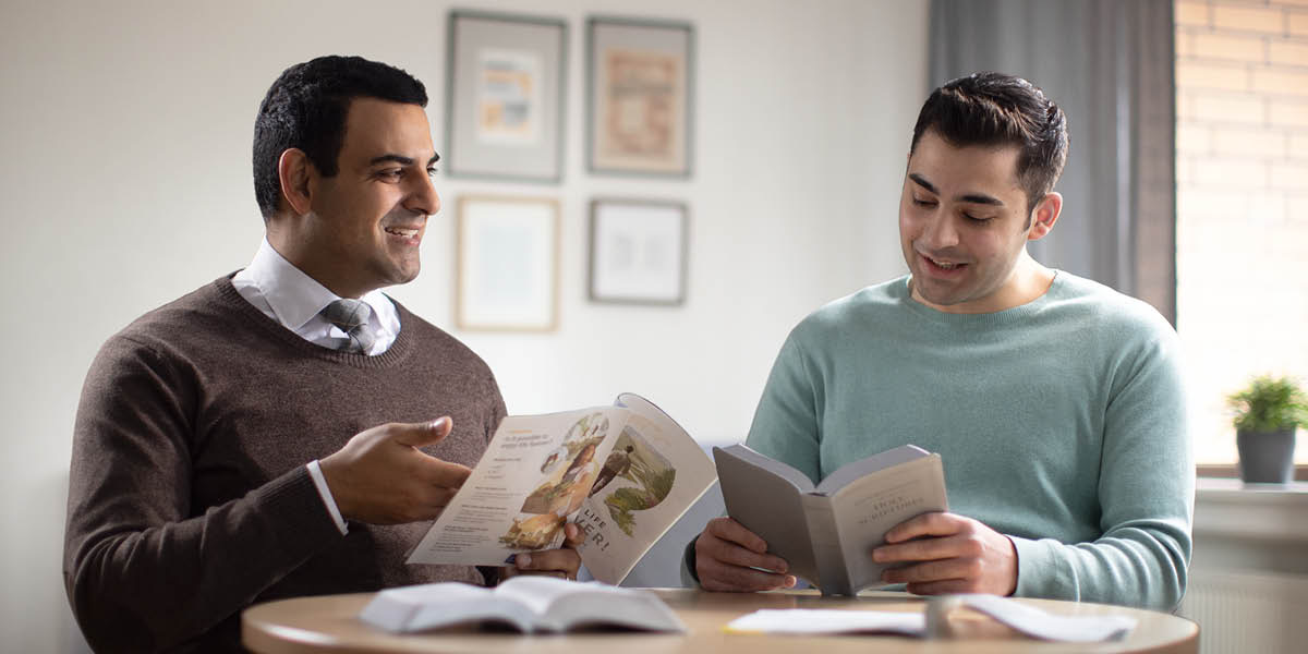 Peteĩ testígo de Jehová ostudia peteĩ persónandi ha oipuru pe folléto “¡Jaikóta vyʼápe pára siémpre!”.
