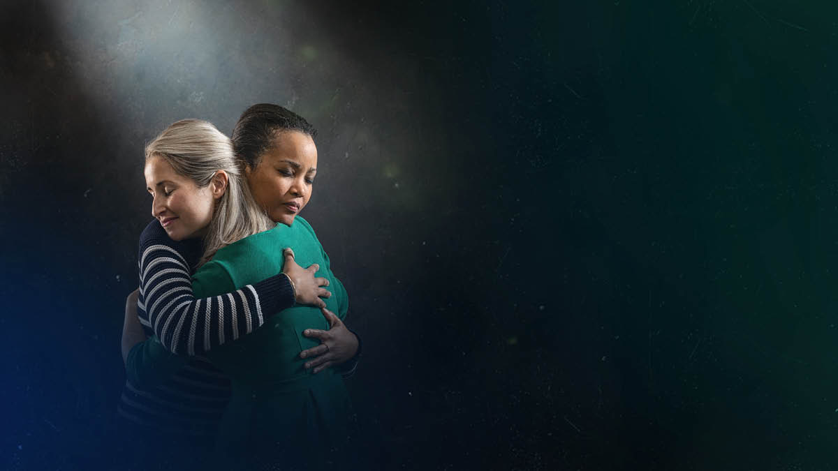 Las palabras “Las cosas del pasado no serán recordadas”, de Isaías 65:17, aparecen junto a dos hermanas que se dan un abrazo y tienen un gesto de alivio en el rostro.