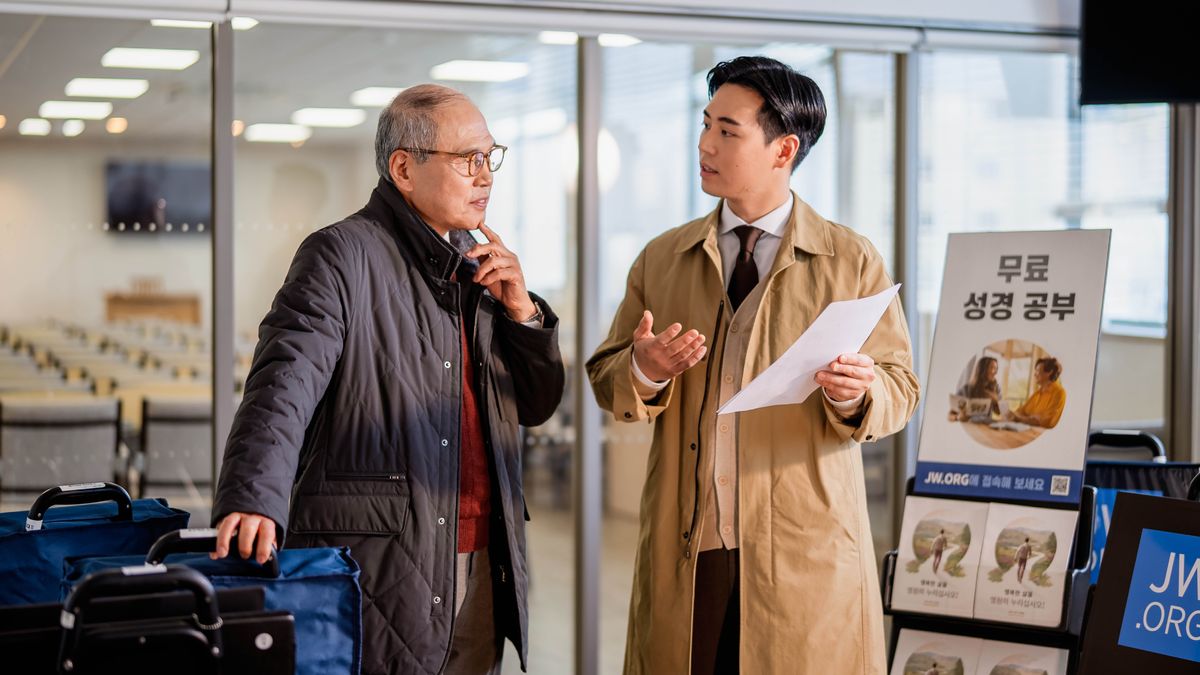 זקן קהילה מבוגר מקשיב היטב לזקן קהילה צעיר ממנו כשהוא מסביר לו איך להשתמש בעגלת בישור במקומות ציבוריים.‏