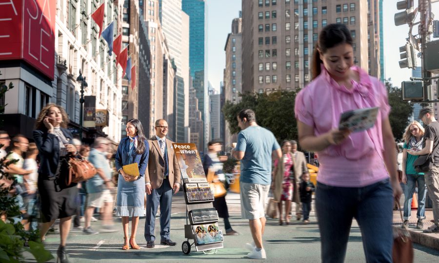 Mag-asawa nga nagatindog sa public witnessing cart—ang iban nga nagaagi nagakuha sing literatura ang iban naman wala