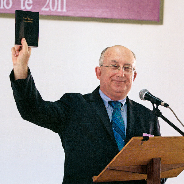 Geoffrey Jackson prisutnima na kongresu pokazuje prijevod Novi svijet grčkih knjiga Biblije na tuvaluanskom jeziku