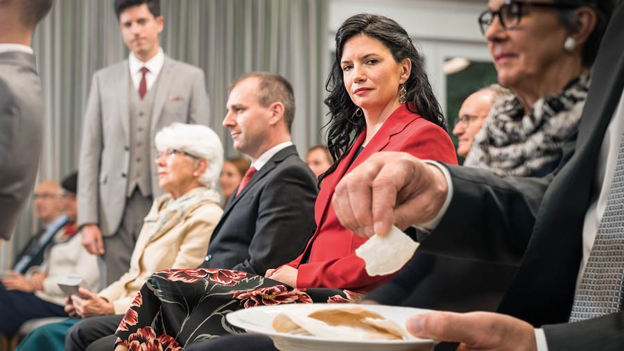 Sestra pažljivo promatra brata koji uzima simbole na obilježavanju Kristove smrti.