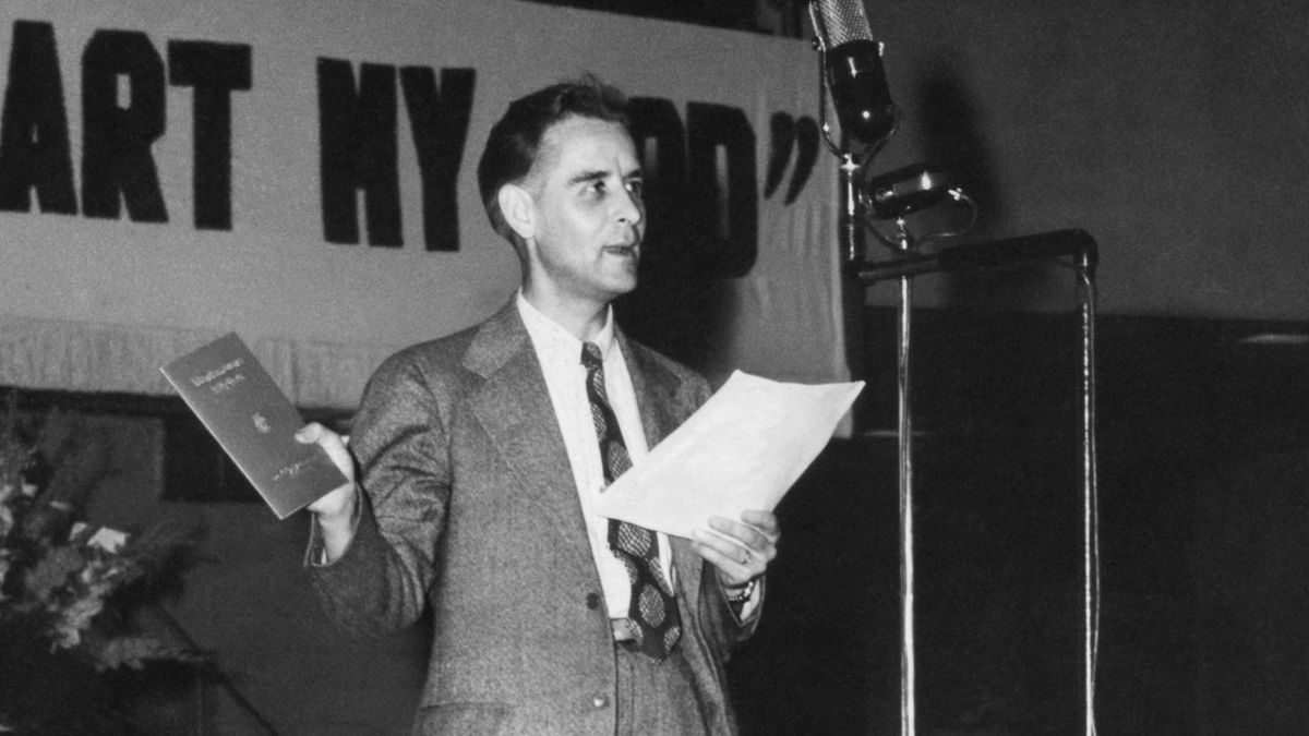 Egy jelenet a „Történelmünk állomásai – Az énekeink (2. rész)” című videóból. F. W. Franz testvér közreadja a „Királyság-szolgálati énekeskönyv” című kiadványt.