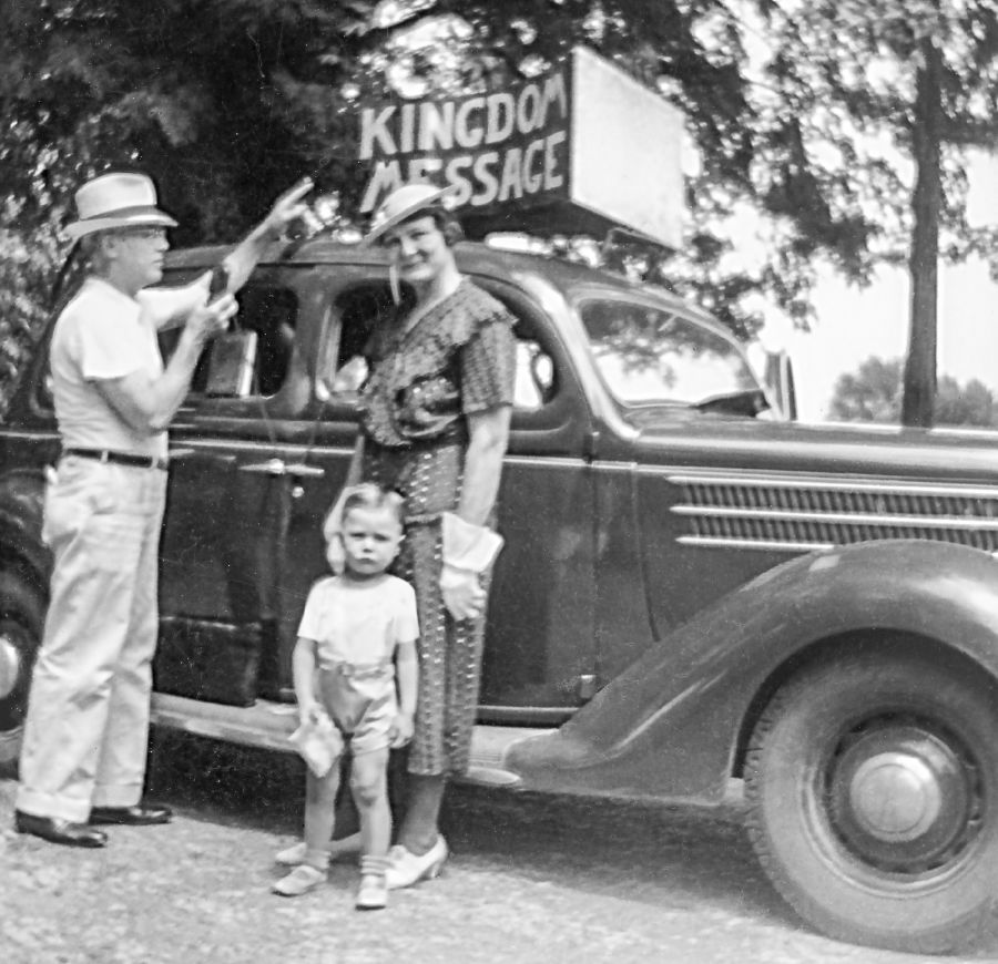 Charles Molohan, lè l te timoun, ki kanpe devan machin son an ansanm ak papa l ak manman l.