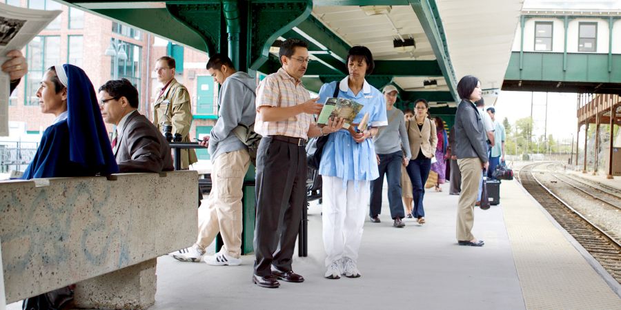 One braddah preaching to one lady at one train stop dat stay busy.