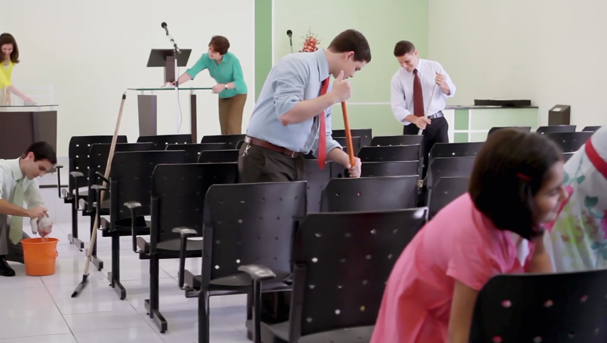 Picha from da video ‘Takin Kea Da Places Wea We Go Fo Worship.’ Guys, wahines, an keikis clean da inside of one Meeting Place.
