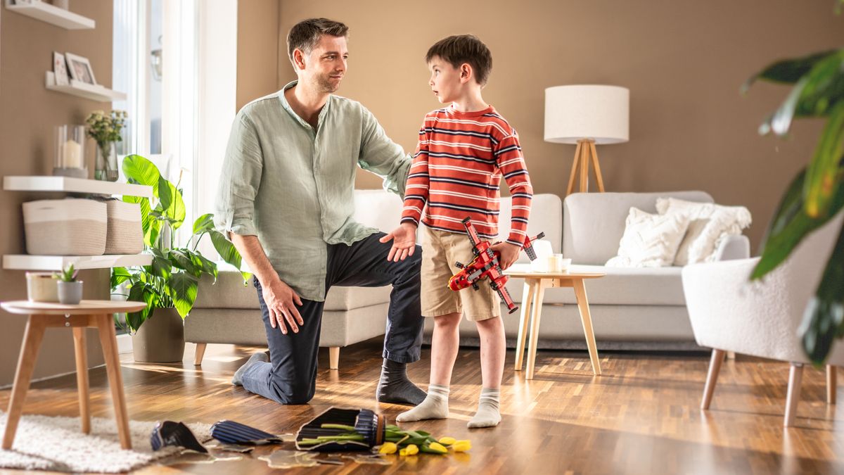 One faddah iz patient az he lissens to his boy tell how he wen break da flowa vase on accident wen he wuz playing wit his toy plane.