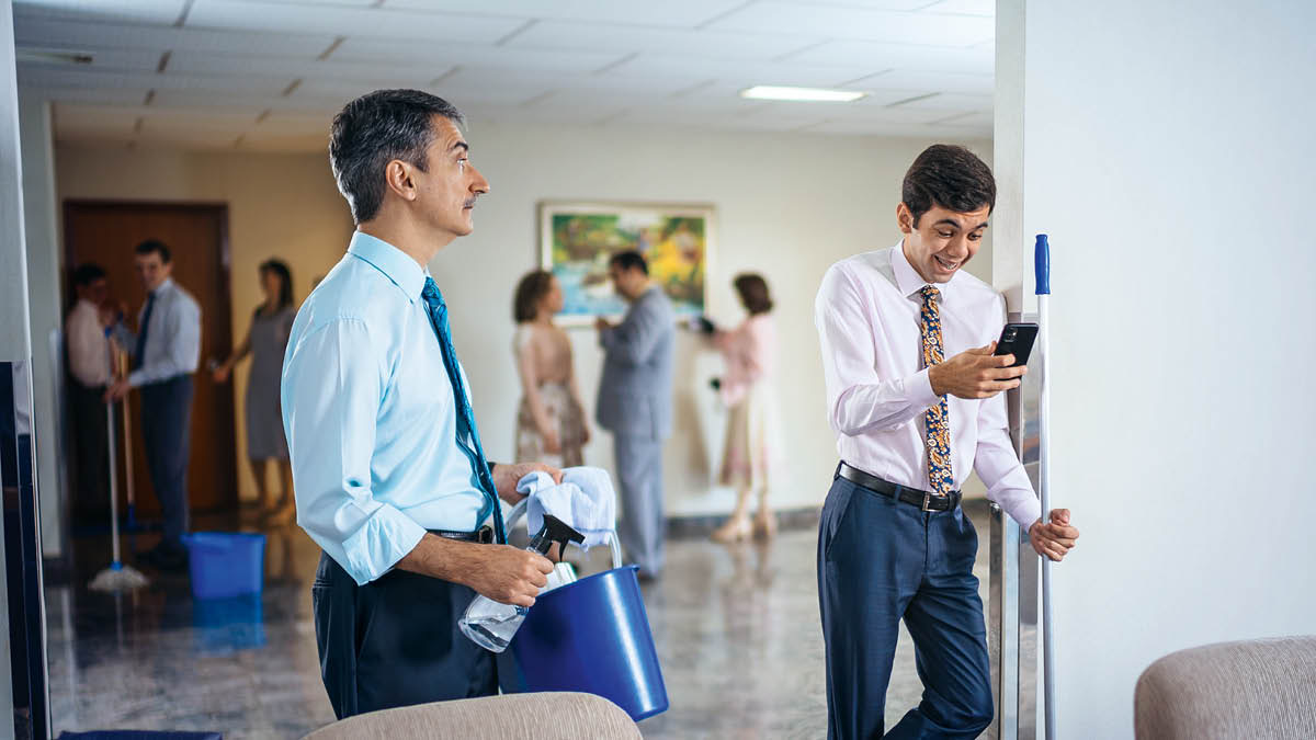An elder watching a young brother who is texting instead of cleaning the Kingdom Hall.