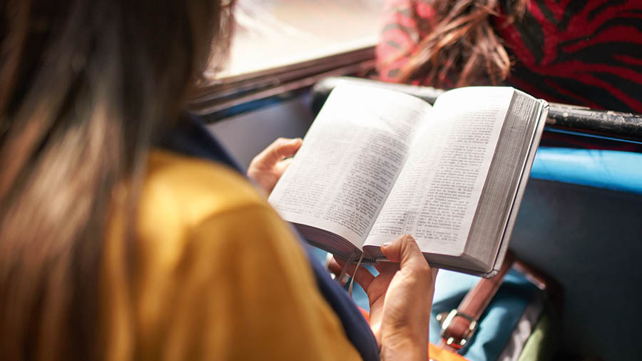Sister a mangbasbasa iti Biblia bayat a nakalugan iti bus.