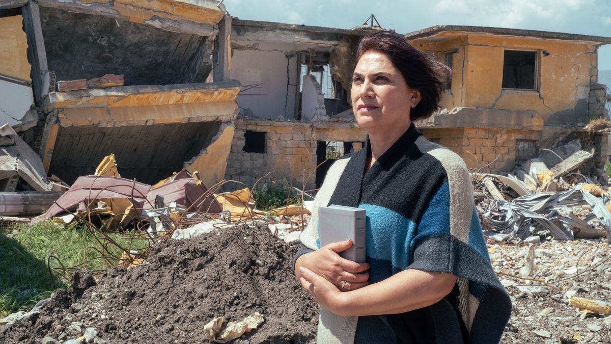 Sister nga adda igge-iggemna a Biblia bayat a sikokompiansa a nakatakder iti sango ti nadadael a balay gapu iti didigra.