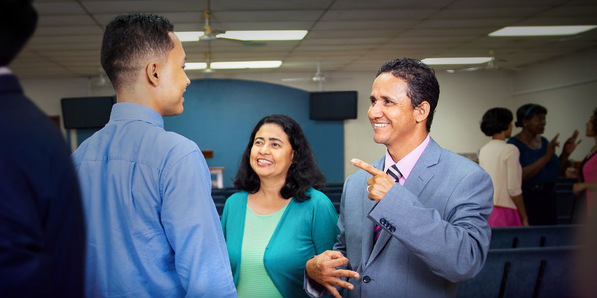 Mario Antúnez, dengan Patricia di sampingnya, menggunakan Bahasa Isyarat Honduras untuk berkomunikasi dengan seorang anak muda di Balai Kerajaan.