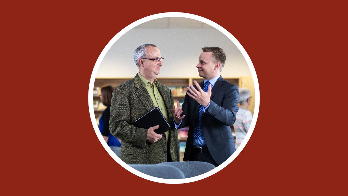 Di Balai Kerajaan, seorang saudara menjelaskan seperti apa perhimpunan itu kepada pelajar Alkitabnya.