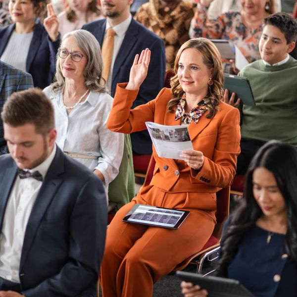Seorang saudari mengangkat tangannya untuk memberikan komentar di Pelajaran ”Menara Pengawal”. Saudara-saudari lainnya juga mengangkat tangan mereka.