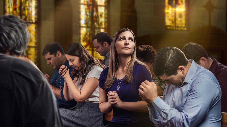 Di gereja, orang-orang sedang berdoa sambil menundukkan kepala mereka, tapi seorang wanita berdoa sambil melihat ke atas.