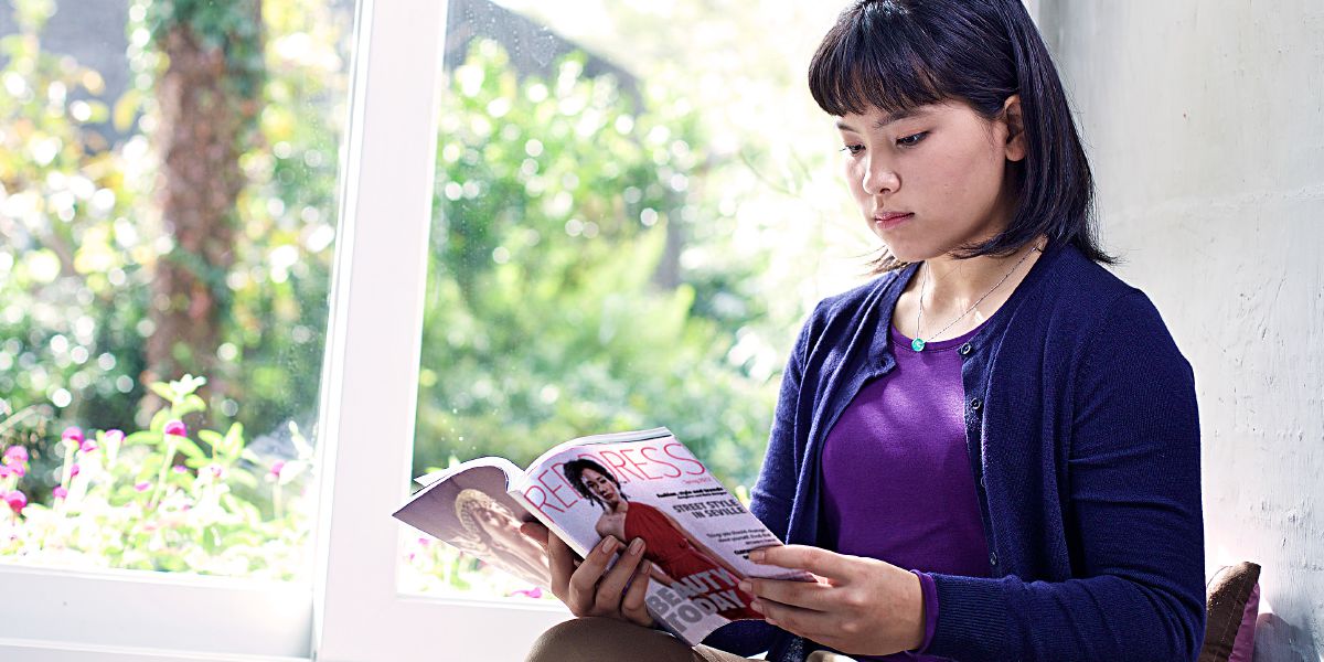 Seorang gadis melihat-lihat majalah fashion