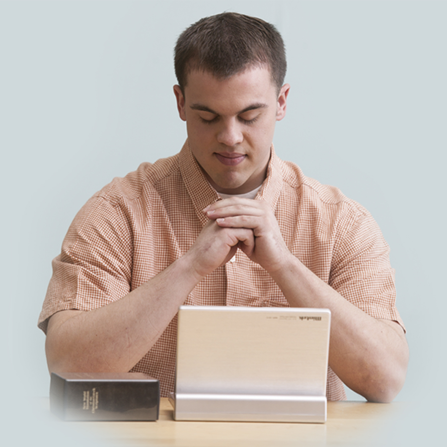 Un ragazzo che studia la Bibbia si dedica a Dio in preghiera